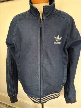 Denim Adidas jacket with two pockets in front has Adidas logo on front and back
